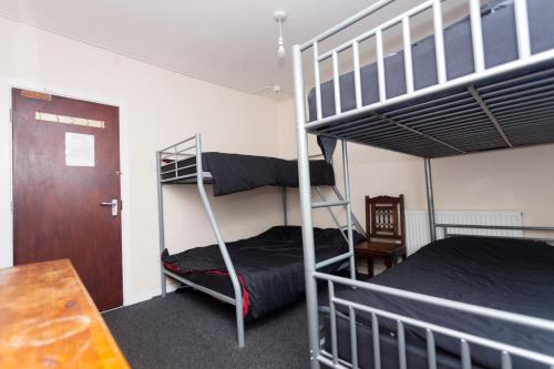 a bedroom with two bunk beds and a table at Budget Hostel in Newcastle upon Tyne