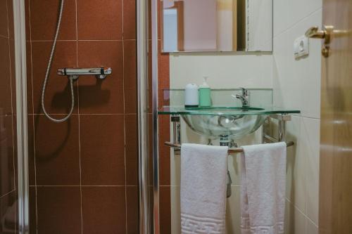a bathroom with a sink and two towels at Ronda Navarra by Valdesierra in Béjar