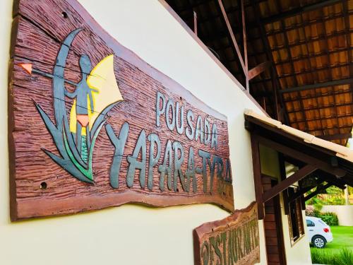 a sign for a restaurant on the side of a building at Pousada Yapara-Tyba in Japaratinga