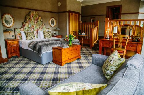 a bedroom with a bed and a couch at Dunkeld House Hotel in Dunkeld