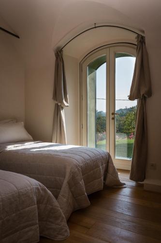 a bedroom with a bed and a large window at Locanda La Raia in Gavi