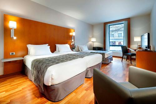 ein Hotelzimmer mit zwei Betten und einem Schreibtisch in der Unterkunft Eurostars Lisboa Parque in Lissabon
