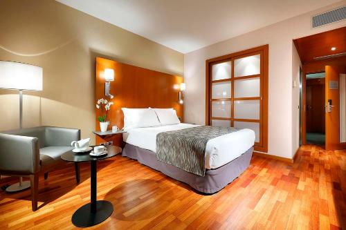 a hotel room with a bed and a chair at Eurostars Lisboa Parque in Lisbon