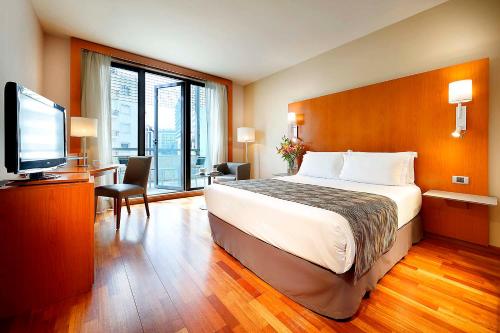 a hotel room with a bed and a flat screen tv at Eurostars Lisboa Parque in Lisbon