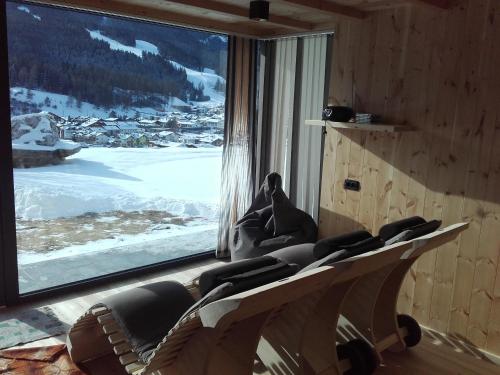a room with a large window with a view of snow at Im Kranzhof in San Candido