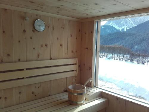 a sauna with a bench and a clock on the wall at Im Kranzhof in San Candido