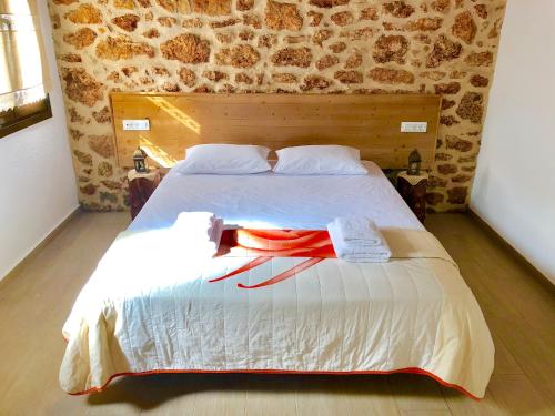 a bedroom with a large bed with two towels on it at Bekos traditional house in Archangelos
