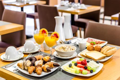 a table with plates of food and glasses of wine at Eurostars Lisboa Parque in Lisbon