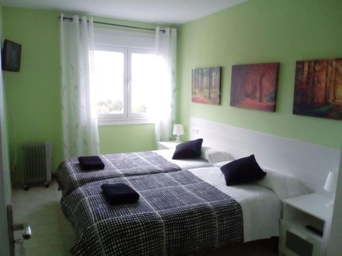 a bedroom with two beds and a window at Albergue Aqua Portomarin in Portomarin
