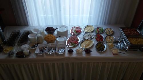 einen Tisch mit Teller mit Lebensmitteln darüber in der Unterkunft Obiekt Tatar - Usługi Hotelarskie in Rawa Mazowiecka
