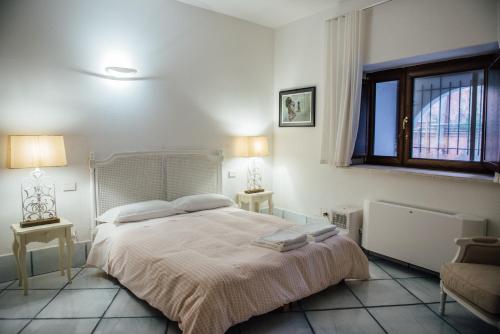 1 dormitorio con 1 cama, 2 mesas y una ventana en L' Ambasciata Gaeta en Gaeta