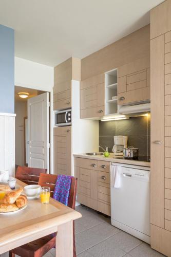 a kitchen with a table with a plate of food on it at Pierre & Vacances Premium Résidence de la Plage in Le Crotoy