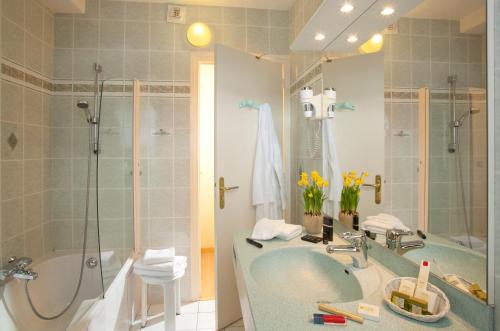 a bathroom with a tub and a sink and a shower at Grand Hotel de Valloire et du Galibier in Valloire