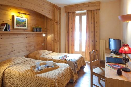 A bed or beds in a room at Grand Hotel de Valloire et du Galibier