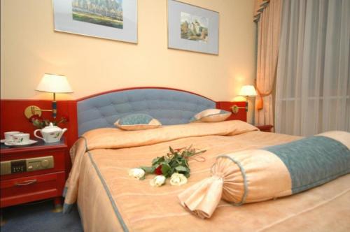 a hotel room with two beds with flowers on them at Hotel Kongresowy in Kielce
