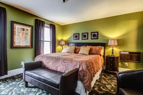 um quarto com uma cama e uma cadeira em Twin Oaks Inn em Saugatuck