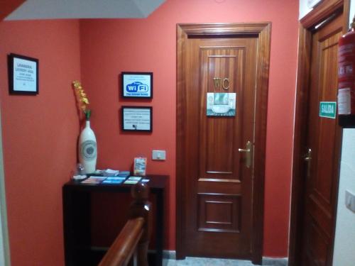 a room with a door and a table with a vase at Albergue Aqua Portomarin in Portomarin