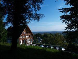 een huis aan de zijkant van een heuvel met een boom bij Hotel Im Hagen in Königswinter