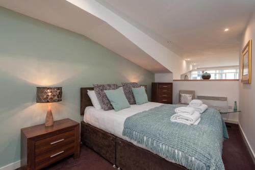 1 dormitorio con 1 cama con toallas en Glasgow City Flats - Merchant City, en Glasgow