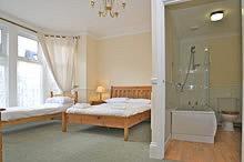 a bedroom with two beds and a bath tub at All Seasons Lodge Hotel in Great Yarmouth