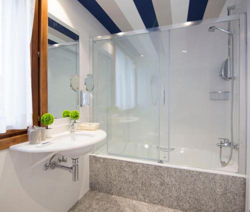 a bathroom with a glass shower and a sink at Hotel Boutique Bahía de Plentzia in Plentzia