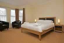 a large bedroom with a bed and two chairs at All Seasons Lodge Hotel in Great Yarmouth