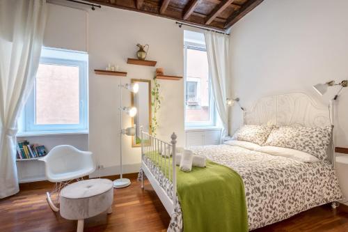ローマにあるEnchanting loft in Trastevereのベッドルーム(白いベッド1台、椅子付)