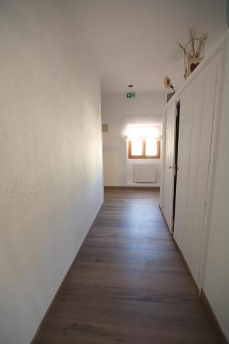 an empty hallway with white walls and wooden floors at Pension Casa Pinilla in Cascante