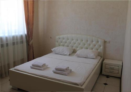 ヴォルゴグラードにあるホテル ソフィアのベッドルーム1室(白いベッド1台、タオル付)