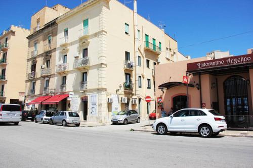 a city street with cars parked in front of buildings at The twins Rooms in Trapani 1 in Trapani