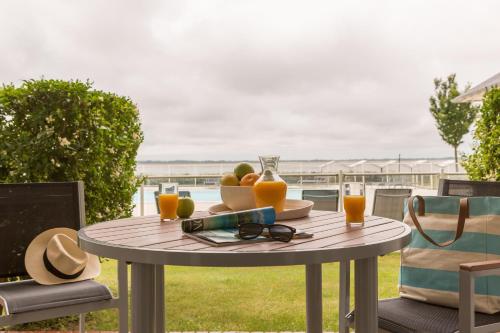 a table with a bowl of fruit and glasses at Pierre & Vacances Premium Résidence de la Plage in Le Crotoy
