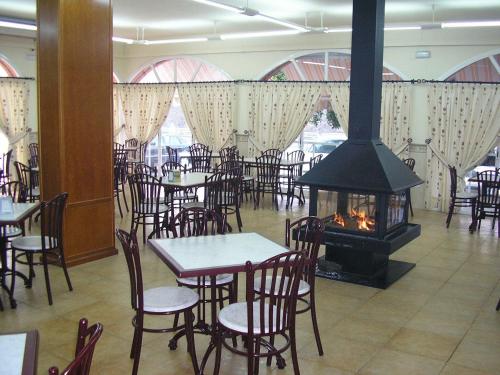 a restaurant with tables and chairs and a fireplace at Nuevo Montesol in Málaga