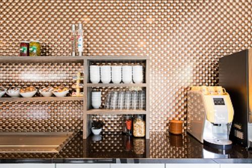 a kitchen with a counter with cups and a coffee maker at Best Western City Hotel Woerden in Woerden
