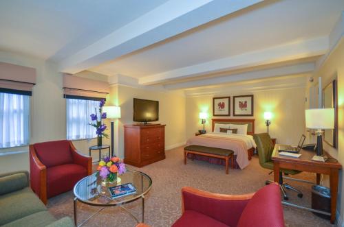 a hotel room with a bed and a living room at San Carlos Hotel New York in New York
