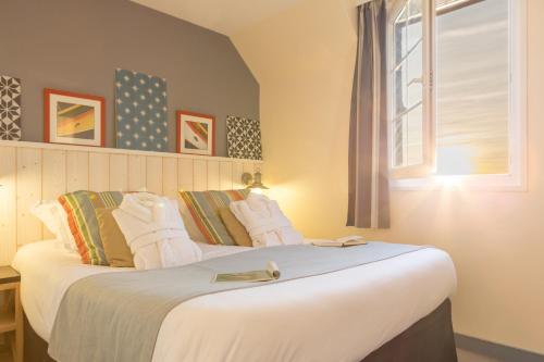 a bedroom with a large white bed with a window at Pierre & Vacances Premium Résidence de la Plage in Le Crotoy