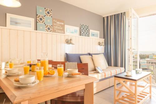 a living room with a table and a couch at Pierre & Vacances Premium Résidence de la Plage in Le Crotoy