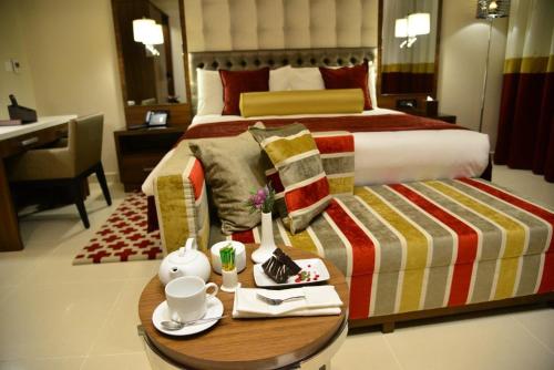 a hotel room with a bed and a table with a table at The Envoy Hotel Abuja in Abuja