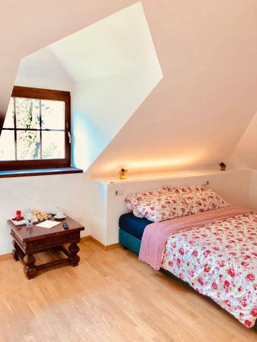 a bedroom with a bed and a table at Villa Anita Rooms in Bolzano