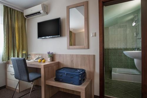 una habitación de hotel con una maleta en el baño en Jasmin Hotel, en Sofía
