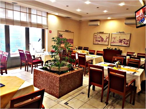 a dining room with tables and chairs in a restaurant at Apartment Dina, Self check in 0-24 in Karlovac