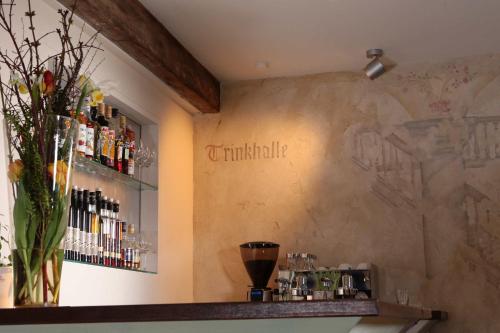 a bar with a vase of flowers on the wall at Hotel Münchner Hof und Blauer Turm in Regensburg