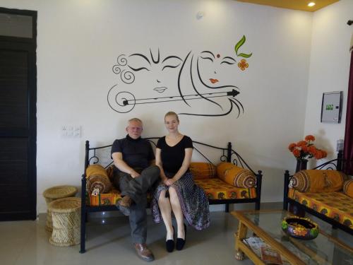 a man and a woman sitting on a couch in a room at Ranthambhore Tiger Valley in Sawāi Mādhopur