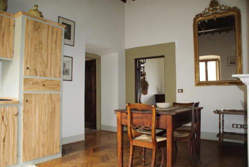 a dining room with a table and chairs and a mirror at Relais La Torre in Chiassa Superiore