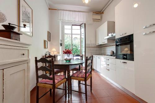una cucina con tavolo e sedie in una stanza di Mimì apartment with garden a Firenze