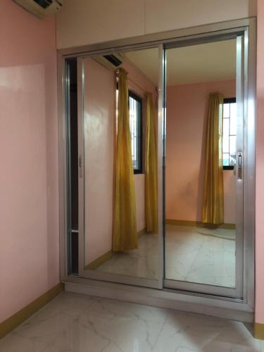 a mirror in a room with yellow curtains at Luzville Residences - C8 in Naic
