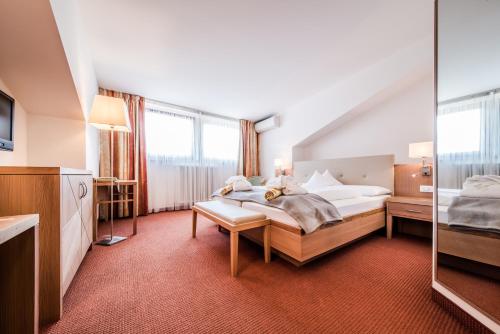 a hotel room with a bed and a tv at Hotel Förstlerhof in Postal