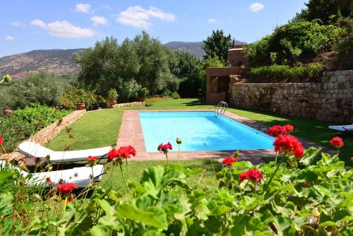 una piscina in un cortile con fiori rossi di Domaine La Source a Ouirgane