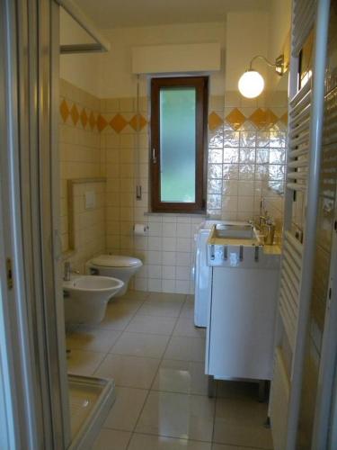 a bathroom with two sinks and a toilet and a tub at B&B Verderosa in Cupra Marittima