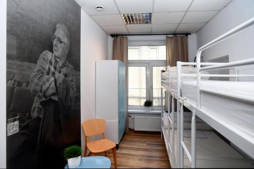 a room with two bunk beds and a large painting on the wall at Warsaw Hostel Centrum Private Rooms & Dorms in Warsaw