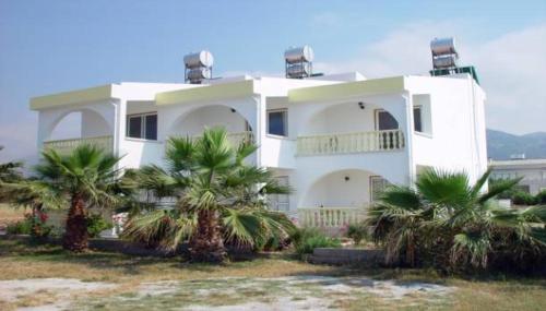 una casa blanca con palmeras delante en Paradise, en Kyrenia